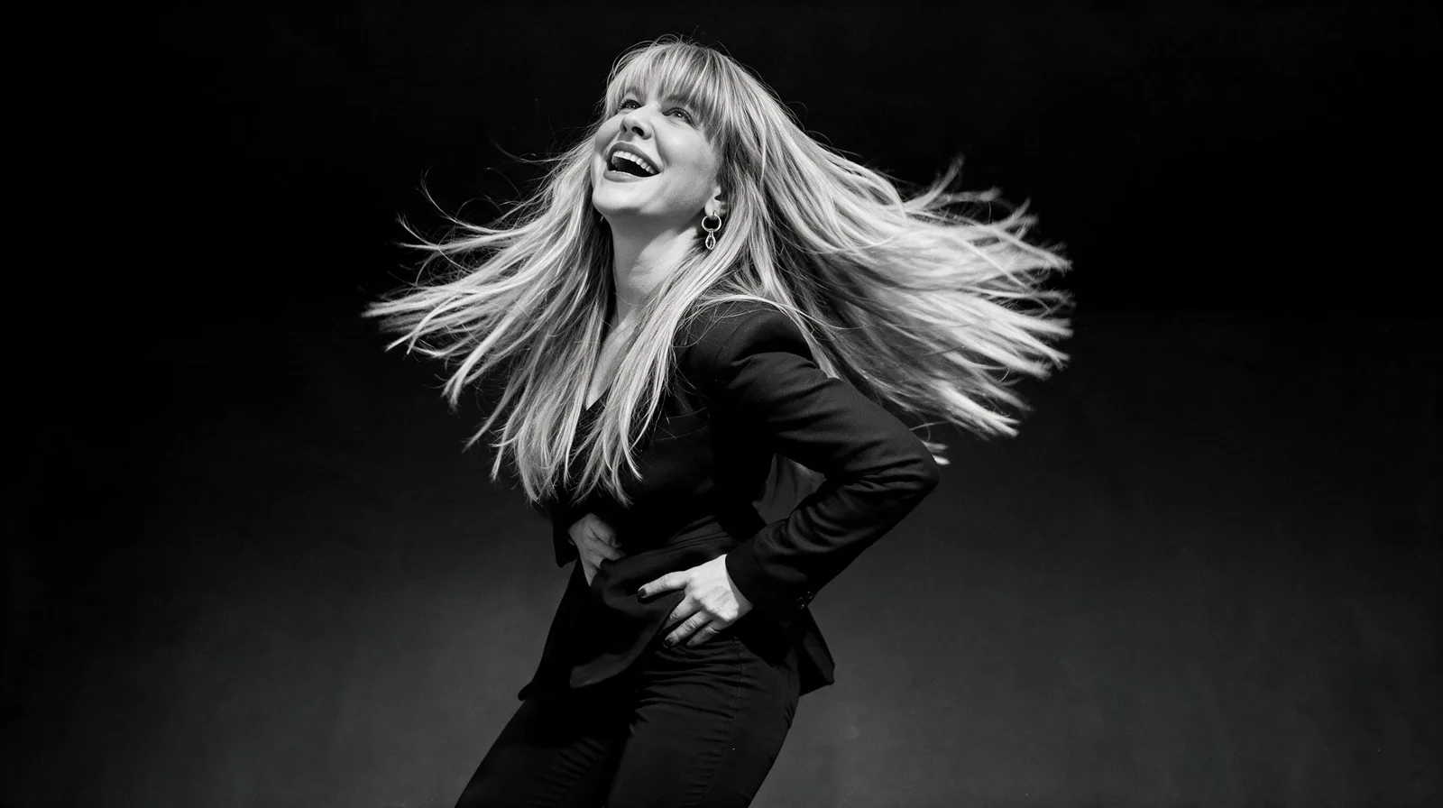 Summer Branam laughing with her hair in motion in a monochrome studio portrait