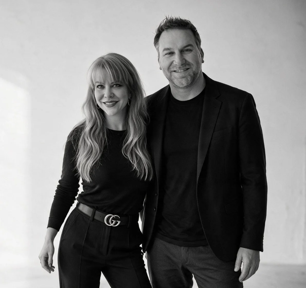 Summer Branam and Randy Branam standing together in a black-and-white studio portrait